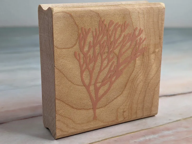 A rubber stamp with an image of a coral reef mounted on a wooden block.
